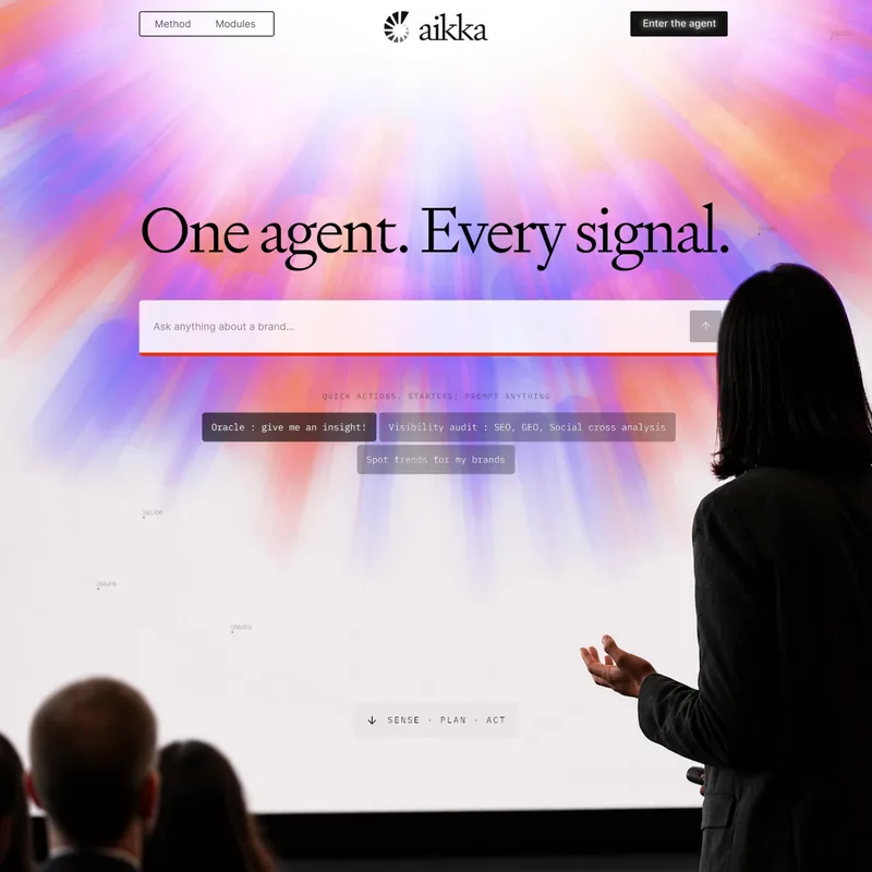 Speaker presenting the Aikka website on a large screen: One agent. Every signal.